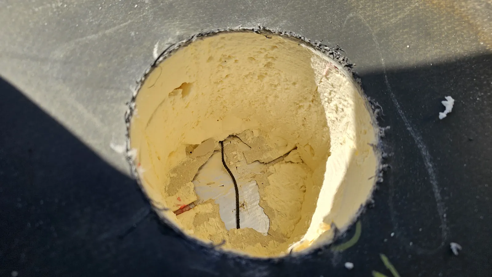 A 100mm cylinder of insulation has been cored out of an existing roof to receive a Vector moisture sensor